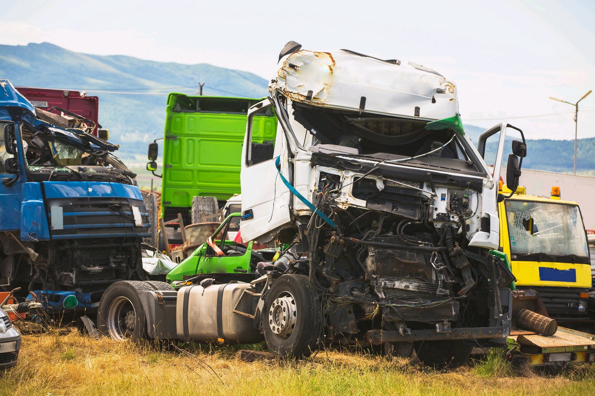 Damaged commercial trucks at a roadside crash scene.