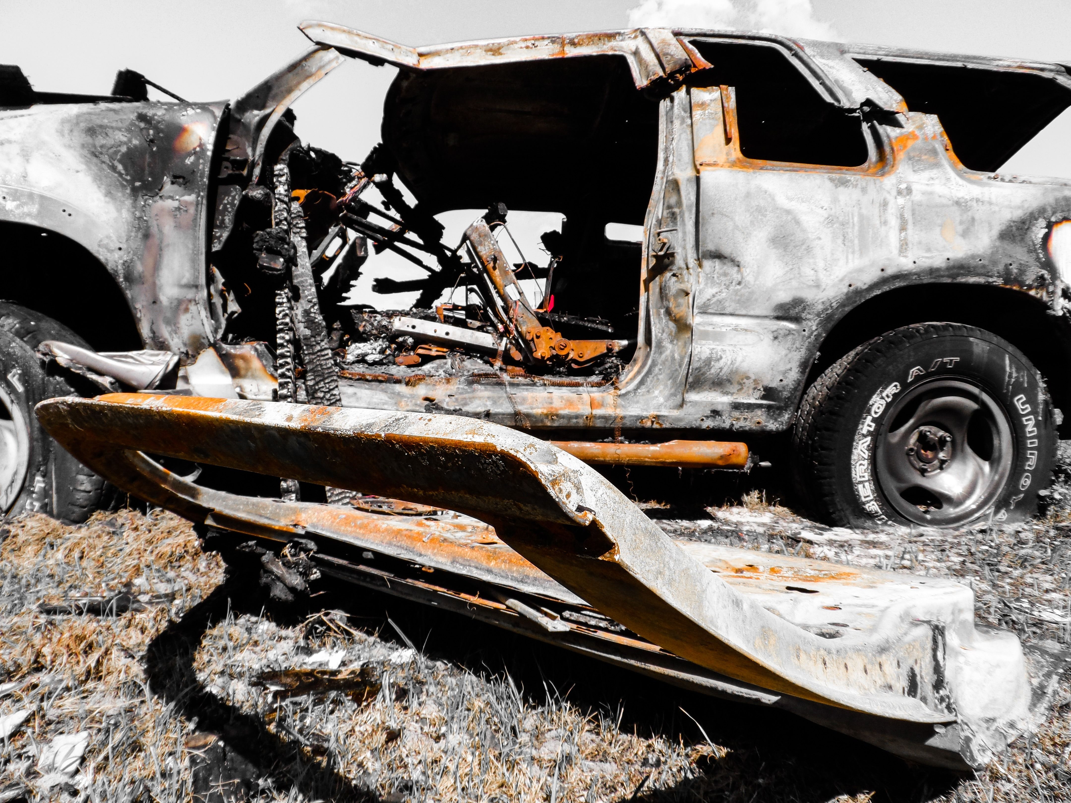 Damaged vehicle at a rural roadside crash scene.
