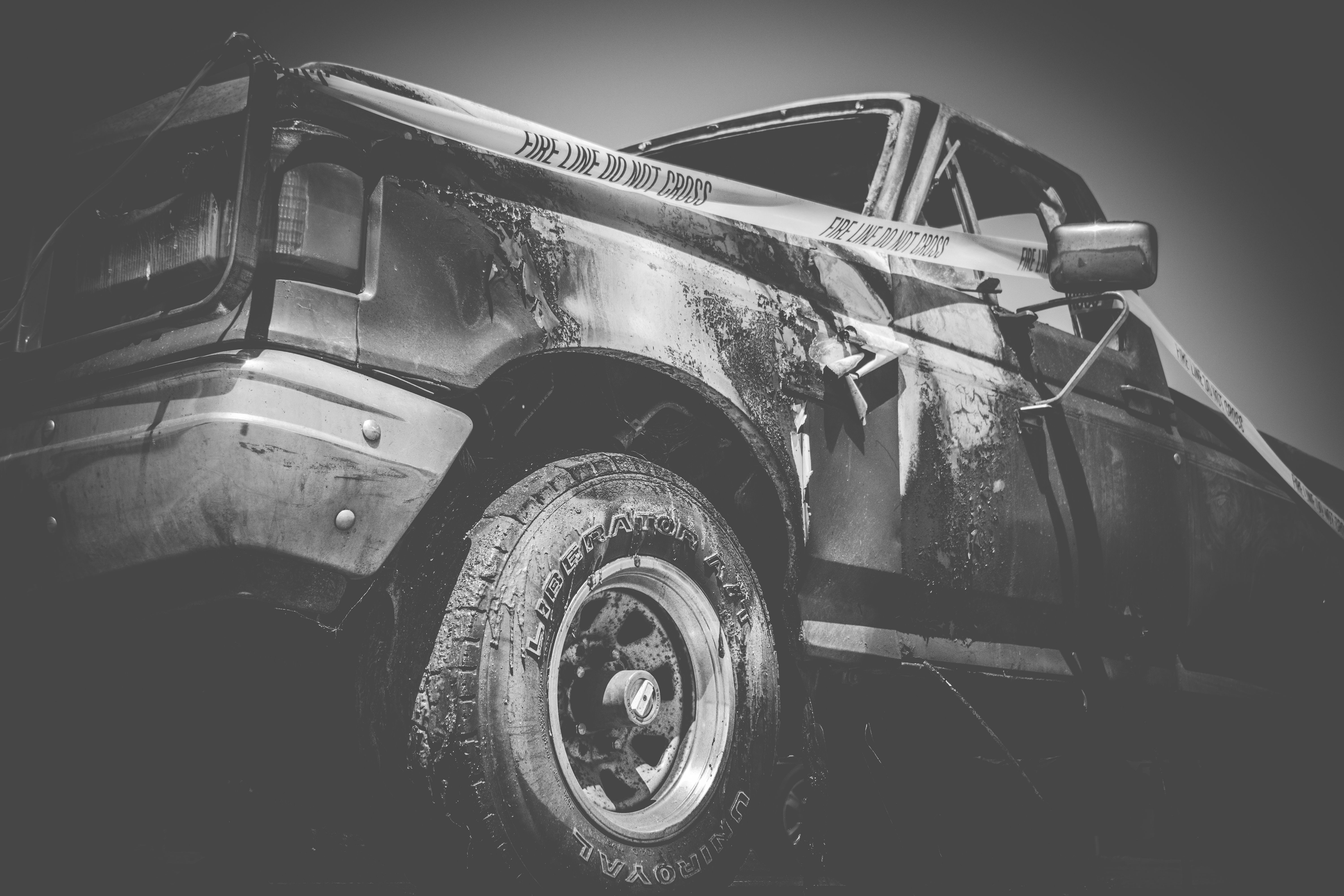 Damaged vehicle with police tape at a crash scene.